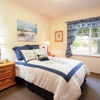 A cozy bedroom with elegant decor and a window letting in natural light.