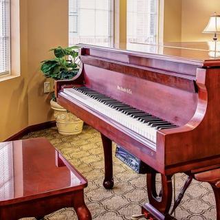 An elegant wooden piano in a well-decorated room.