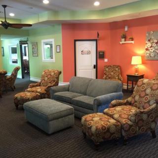 A cozy living room featuring colorful walls and a variety of comfortable seating options.