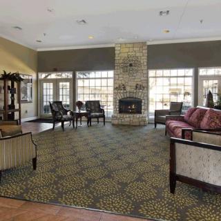 A spacious living room with a central fireplace, ample seating, and large windows.