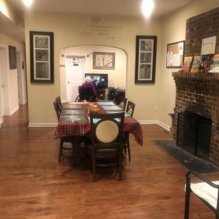 A cozy dining room with a wooden table and chairs, a fireplace, and warm decor.
