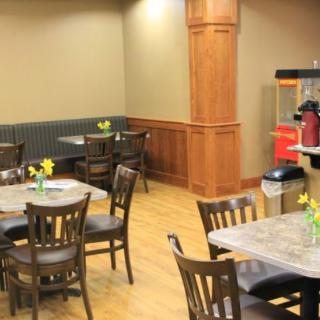 A cozy cafe dining area with tables, chairs, and floral decorations.