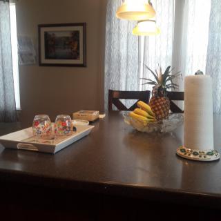 A kitchen island with a fruit bowl and glasses on a tray.