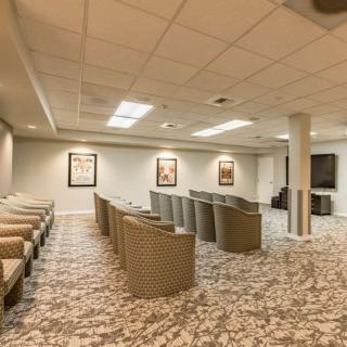 A modern conference room with seating arranged in rows and a patterned carpet floor.