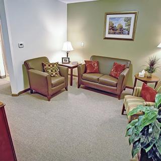 A cozy living room with sofas, chairs, and decorative elements.