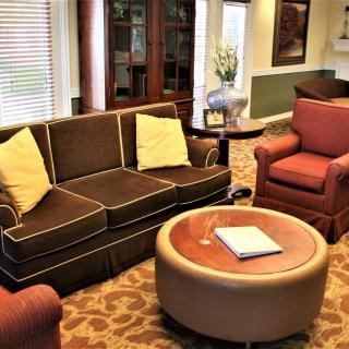 A cozy living room with a brown sofa, armchair, and round coffee table.