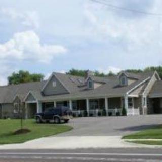A suburban house with a driveway and a vehicle parked outside.