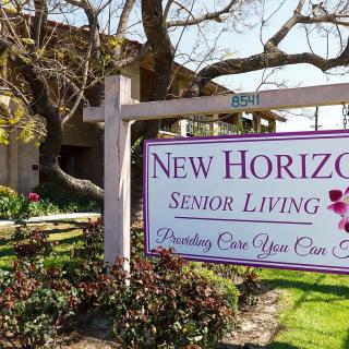 The sign for New Horizons Senior Living facility in a landscaped outdoor setting.