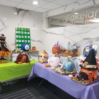 A display of creatively decorated pumpkins for a Halloween contest in an indoor setting.