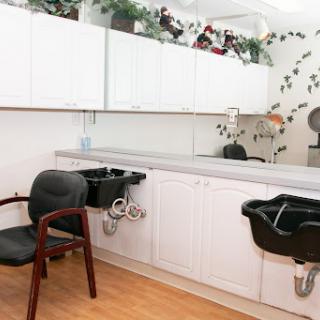 A clean and organized hair salon interior featuring styling chairs, mirrors, and modern decor.