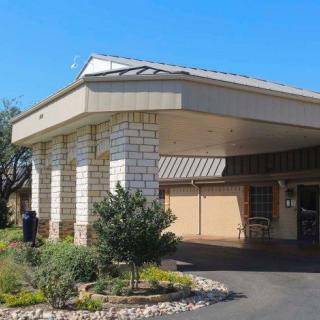 A building with a covered entrance and surrounding landscape.