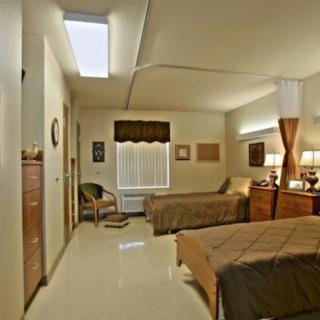 A cozy room with two beds and warm lighting, featuring simple decor.