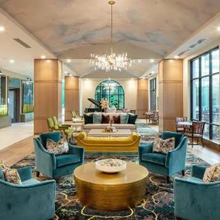 A luxurious hotel lobby with elegant furnishings, a grand chandelier, and a grand piano.