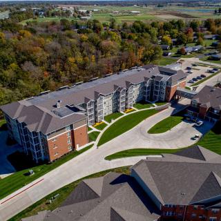 An aerial view of a suburban apartment complex surrounded by trees and greenery.