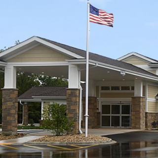 The entrance of a building with an American flag flying overhead.