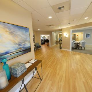 A modern interior hallway with artwork and decorative furniture.