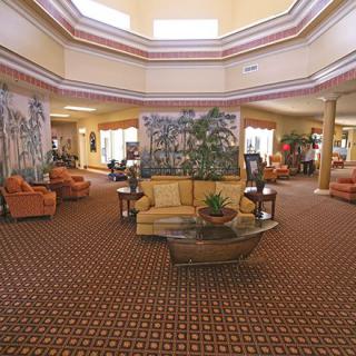 A spacious hotel lobby with comfortable seating areas and decorative plants.