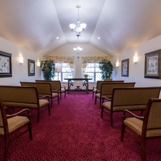 An interior view of a chapel with red carpeting and arranged seating.