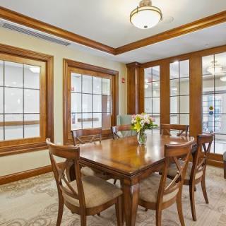 A cozy dining room with wooden furniture and a vase of flowers on the table.
