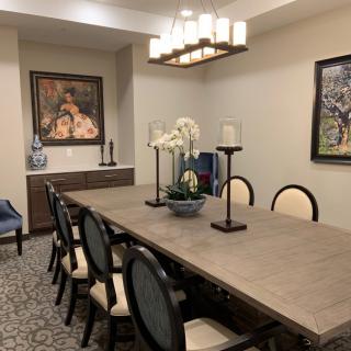A well-decorated dining room with a large table, elegant chairs, and artistic decor.