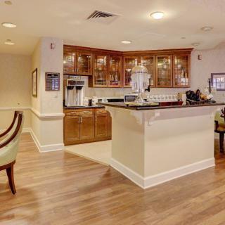 A cozy kitchen area with wooden cabinets and a seating space.