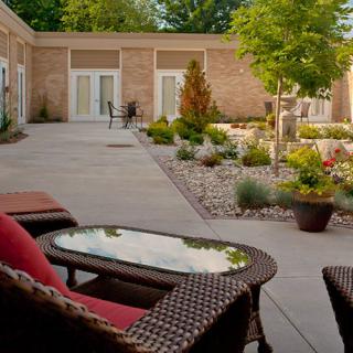 A tranquil courtyard featuring comfortable outdoor seating and a beautifully landscaped garden.