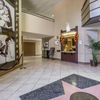 A hotel lobby with portraits on the wall, a reception desk, and decorative elements.