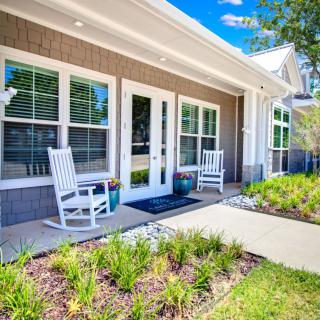 A sunny porch with rocking chairs and a garden path.