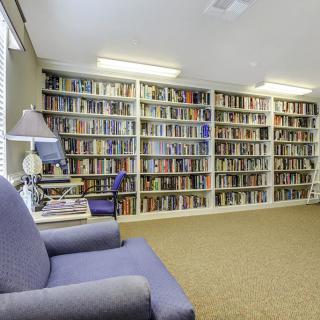 A cozy library with bookshelves filled with books and comfortable seating.