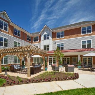 A modern residential building with a landscaped courtyard and outdoor seating area.