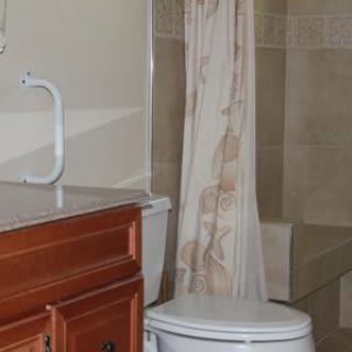 A bathroom featuring a toilet, sink, and shower with a curtain.