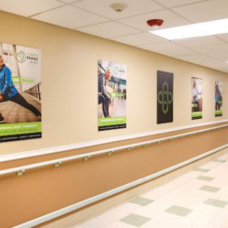 A brightly lit hallway featuring motivational fitness posters, promoting health and rehabilitation.