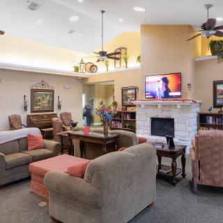 A cozy living room with comfortable seating, a fireplace, and a television.