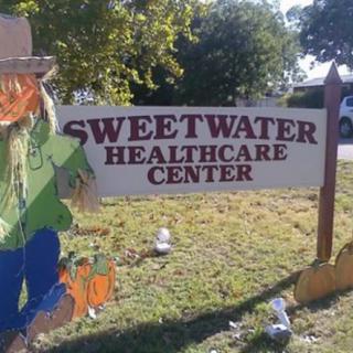 A sign for Sweetwater Healthcare Center decorated with autumn-themed figures.