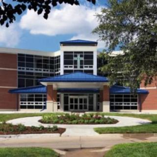 A modern school building with a blue roof and glass facade.