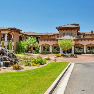 A luxurious mansion with a beautifully landscaped entrance and fountain.