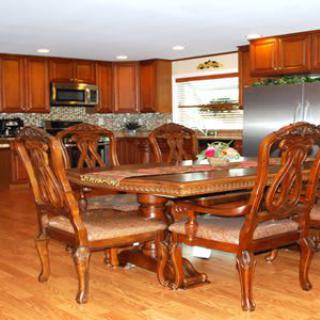 A cozy dining area with polished wooden furniture and cabinets, set within a modern kitchen.
