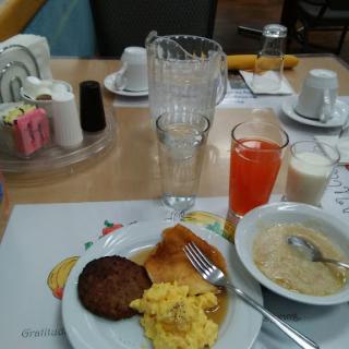 A wholesome breakfast spread featuring scrambled eggs, sausage, toast, and beverages.