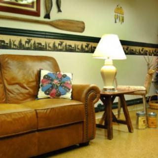 A cozy living room with a leather couch, decorative pillow, and warm lighting from a table lamp.