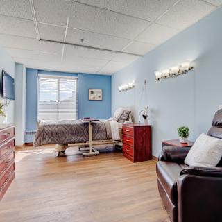 A serene hospital room designed for patient comfort, featuring calming blue walls and ample natural light.