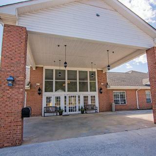 The image shows the entrance of a brick building with a covered walkway.