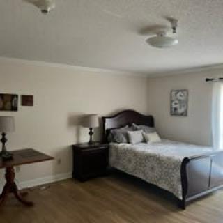 A cozy bedroom with a wooden bed, nightstands, and a small table.