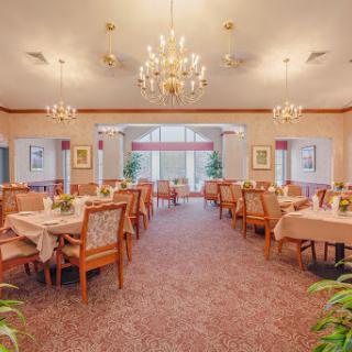 An elegant dining room setup featuring chandeliers and inviting tables for guests.