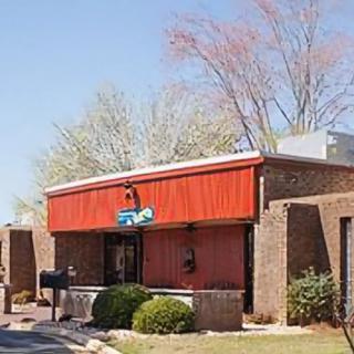 Exterior view of a brick restaurant building with a red awning.