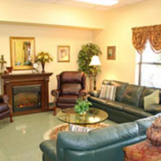 A cozy living room with sofas, armchairs, and a fireplace.