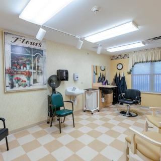 Interior of a hair salon with chairs, equipment, and a checkered floor.