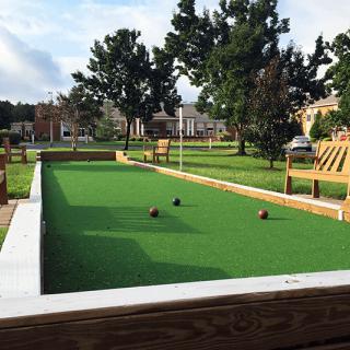 An outdoor bocce ball court in a park setting.
