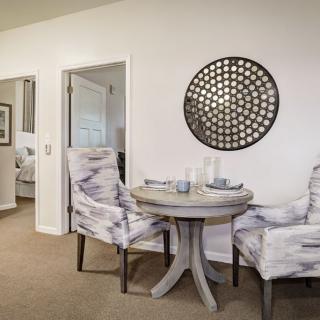 A cozy dining area with stylish chairs and a round table, complemented by modern wall decor.