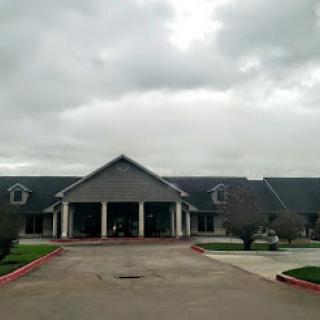A serene entrance to a well-designed building under a cloudy sky.