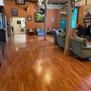 A cozy interior with hardwood flooring, comfortable seating, and diverse artwork displayed on the walls.